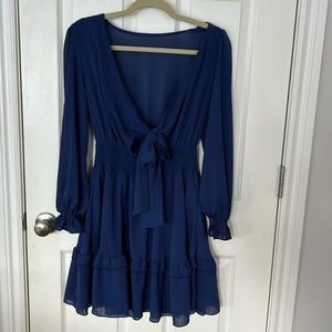 Women’s long sleeve, navy blue flow dress. Open back with bow closure.